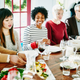 Thanksgiving holiday table with people gathered around eating meal